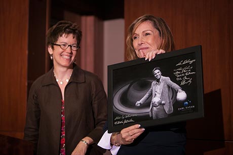 Ann Druyan holds a framed photo of Carl Sagan at the ceremony as Gretchen Ritter, the Harold Tanner Dean of the College of Arts and Sciences, looks on.