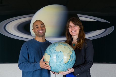 Chris Kitchen/University Photo -- Ramses Ramirez, left, and Lisa Kaltenegger hold a replica of our own habitable world, as they hunt for other places in the universe where life can thrive.